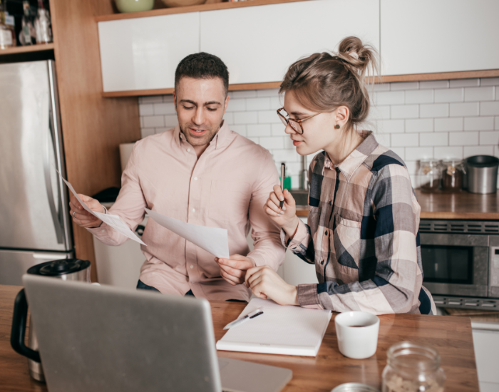 Couple Reviewing Paperwork In Kitchen